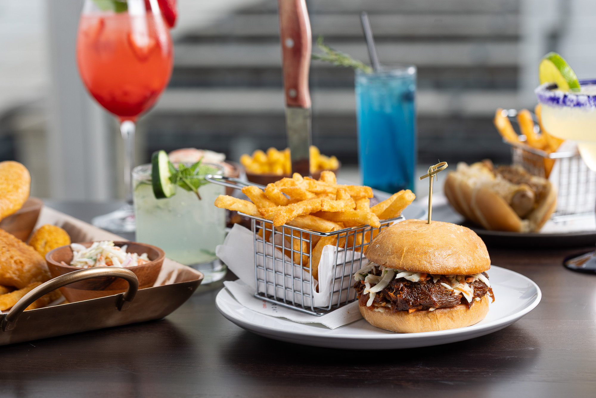 BBQ pulled pork sandwich with crispy fries and cocktails